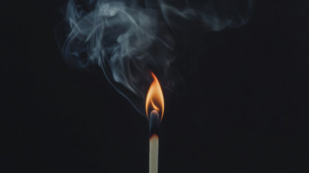 A detailed shot of a burning matchstick, with smoke spiraling upward as the flame flickers, highlighting the fleeting nature of fire.の素材