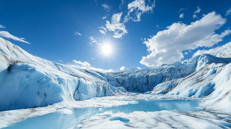 A stark image of a melting glacier with visible cracks and pools of water, set against a bright blue sky, highlighting the effects of global warmingの素材