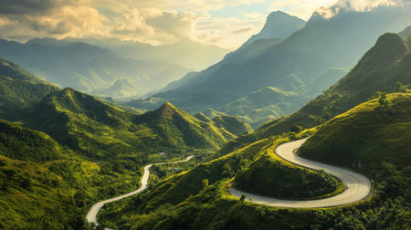 Scenic view of a winding mountain road with breathtaking views of lush green valleys and towering peaks, bathed in golden sunlight.の素材