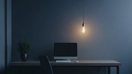 A minimalist workspace with a single pendant light bulb hanging from the ceiling, illuminating a clean, modern desk with simple decor.の素材