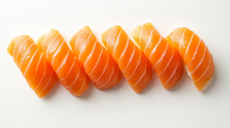 High-definition image of raw salmon sushi pieces arranged on a white background, highlighting the freshness and vibrant color of the fishの素材