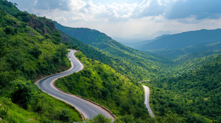 A scenic mountain road winding through lush greenery, with dramatic views and a clear, open sky, ideal for capturing the beauty of nature and travelの素材