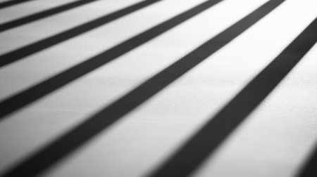 A close-up view of shadows created by stripes of light on a smooth surface. The interplay of light and shadow offers a minimalist and abstract aesthetic.の素材