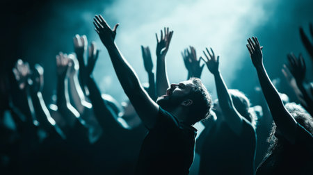 A dynamic image capturing a crowd joyfully celebrating under striking lighting, with hands raised high, embodying the energy and emotion of a live performance.の素材