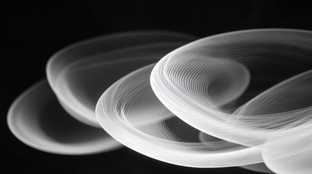 Close-up of white smoke rings swirling and overlapping in an intricate pattern on a black backgroundの素材