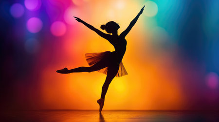 A dynamic image of a dancer in mid-pose, captured as a silhouette against a brightly colored stage light, emphasizing the grace and movement.の素材