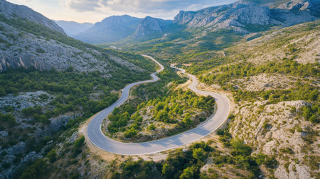 A picturesque aerial view of a road winding through a mountain range, capturing the beauty of travel by car through scenic landscapesの素材