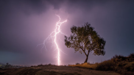 A spectacular scene featuring a lightning strike that dramatically illuminates a solitary tree against ominous storm clouds, capturing the raw power of nature.の素材