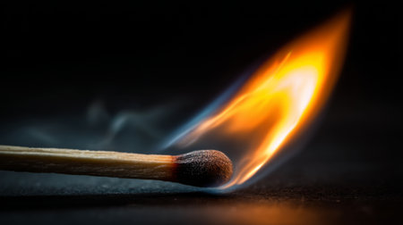 A vibrant close-up shot of a burning matchstick against a dark background, showcasing the mesmerizing flames and delicate smoke for a striking visual impact.の素材