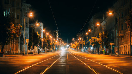 A tranquil nighttime street view showcases an empty road illuminated by city lights. The serene atmosphere highlights urban beauty and perfect stillness in the city.の素材