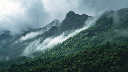 Explore the breathtaking beauty of majestic mountains cloaked in greenery, with low-hanging clouds creating a mystical atmosphere. Perfect for nature lovers.の素材