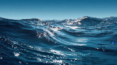 The image captures a beautiful ocean scene with gentle waves glistening under bright sunlight. This serene and tranquil seascape invites relaxation and peacefulness.の素材