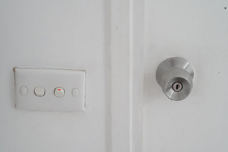 White wall with metal door knob and light switch panel, minimalistic interior, clean and simple...
