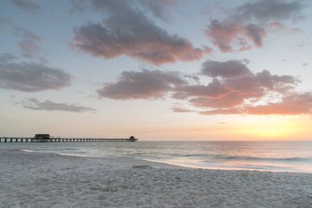 A pastel sunset on the Gulf of Mexico at the pier in Naples, Floridaの写真素材