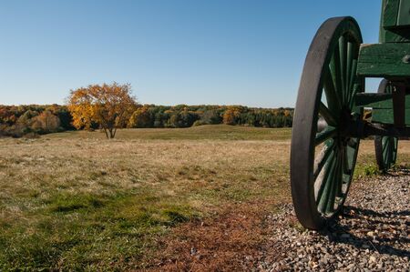 A wagon sits on top of a hill overlooking a fieldの写真素材