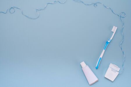 Toothbrush, toothpaste and dental floss on a light blue backgroundの写真素材