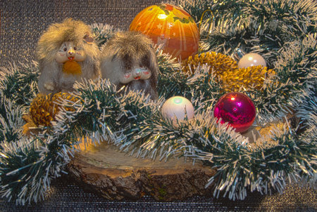 A wooden stump, a green garland with white ends, Christmas tree balls : a red one, two white ones, a large yellow one, two small toy mice, three pine cones.の写真素材