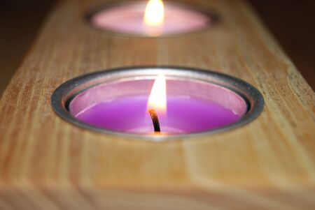 Scented candles held within a wooden blockの写真素材