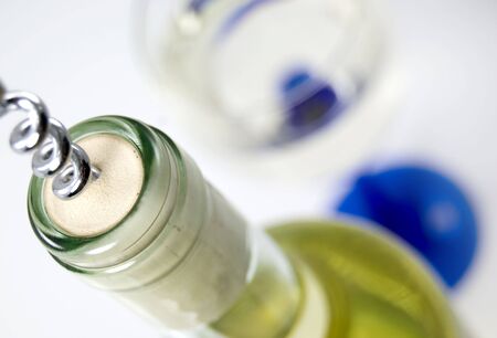 Opening a bottle of white wine, glass ready waiting in the backgroundの写真素材