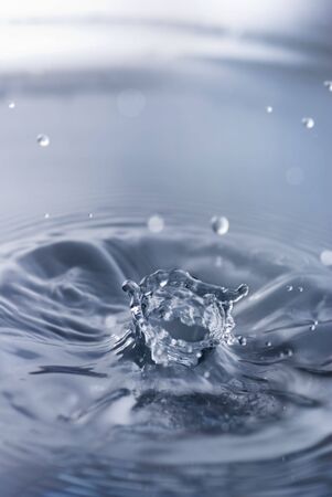 Water splash with angled crown and ripplesの写真素材
