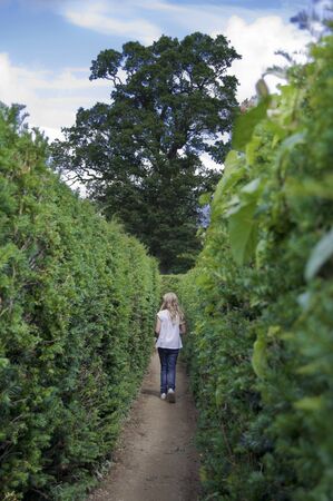Young girl in a maze looking for the way out.の写真素材