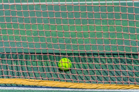Tennis court, grid and ball. Green court. The ball is in the net.の写真素材