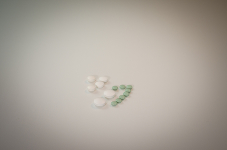 Tablets are laid on a white table and a bottle nearby.の写真素材