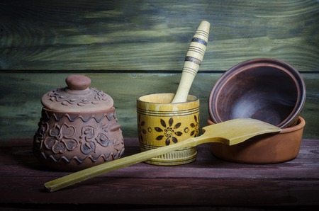 Empty clay pots on a wooden background illuminated in the dark with a flashlight.の写真素材
