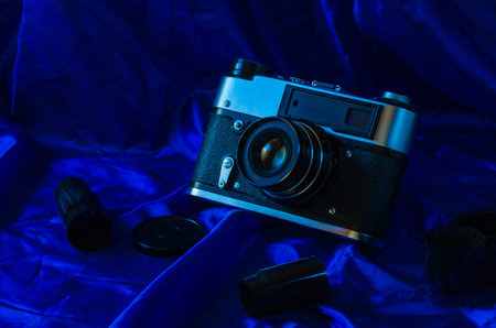 Still life photographic film and film camera on different backgrounds.