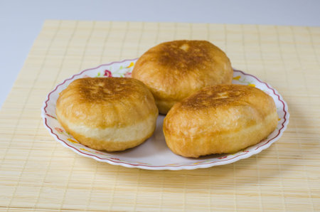 Delicious meat pies belyashi on a light background. Russian, Bashkir and Tatar cuisine.