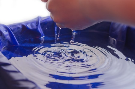 Children's hands in water and with water.の写真素材