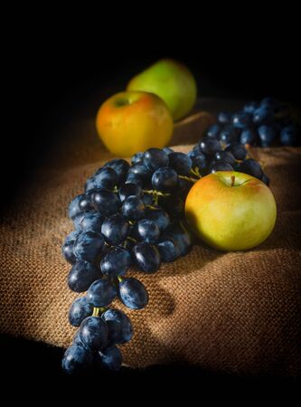A good rustic with grapes and apples on burlap.の写真素材
