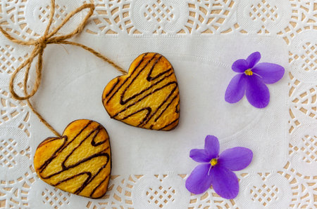 Festive gingerbread cookies for Valentine's day in the shape of a heart lie on a white openwork...