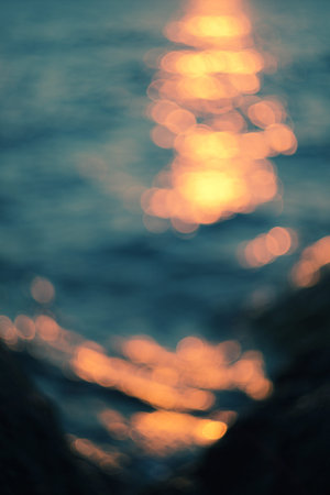 Golden sunlights on blue water background.の写真素材