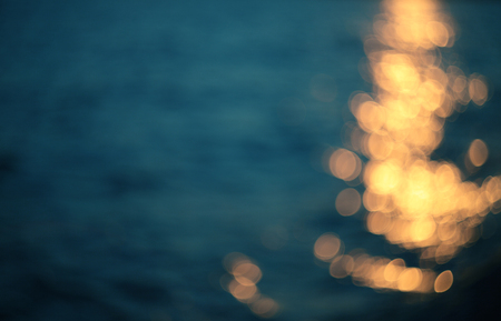 Golden sunlights on blue water background.の写真素材