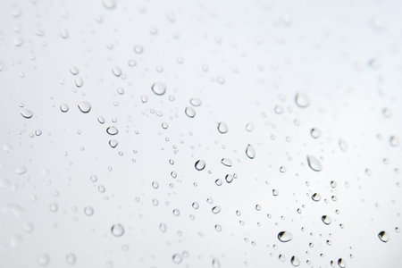 Monochrome blurred drops background with natural lighting.Rainy window.の写真素材