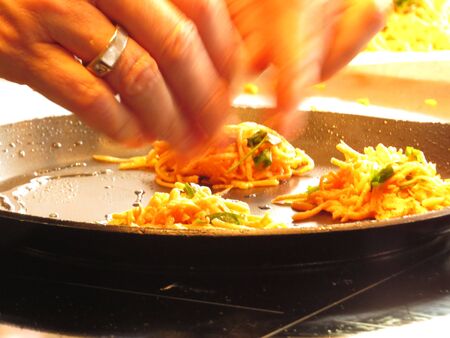 close up on chef hands making sweet potato rosti in heavy skilletの写真素材