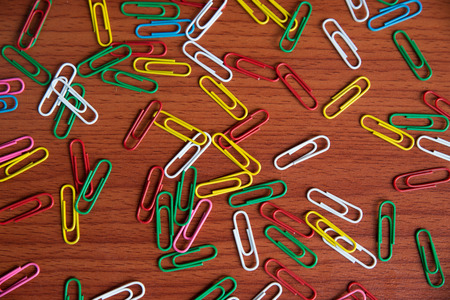 A colorful paper clip against wooden backgroundの写真素材