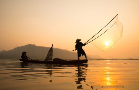 fishermans on boat with sunrise background, the Mekong River in Thailand.の写真素材