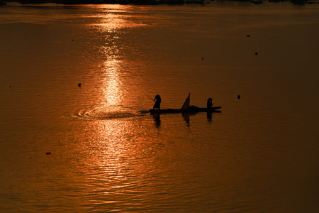 fisherman on boat with sunrise background, the Mekong River in Thailandの写真素材