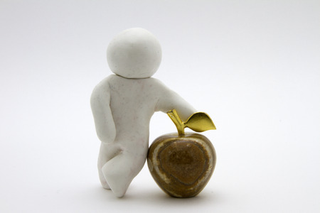 Plasticine character and apple. Isolated on white backgroundの写真素材