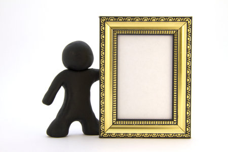 Black plasticine character and gold photo frame. Isolated over white backgroundの写真素材