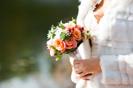 Bride holding an autumn wedding bouquetの写真素材