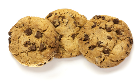 A macro photo of three crunchy chocolate chips cookies, shot from above on a white backgroundの写真素材