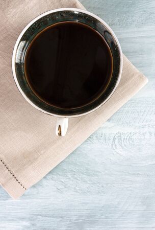 A photo of a vintage cup of black coffee, shot from above on a teal blue background, with copyspaceの写真素材