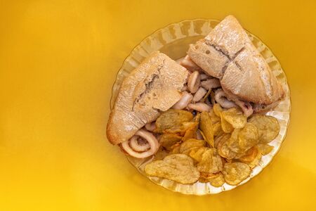 A photo of a squid sandwich, traditional Madrid snack, shot from above on a vibrant yellow background, with copyspaceの写真素材