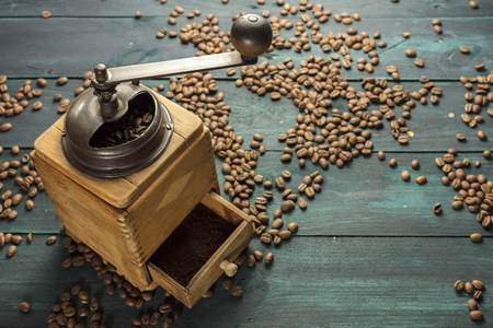 Vintage coffee grinder with scattered beans and copyspaceの写真素材