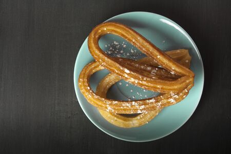 Traditional Spanish churros with chocolate on black backgroundの写真素材
