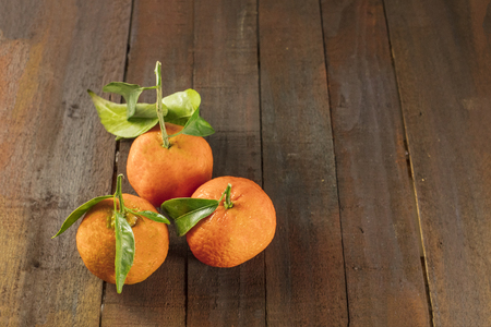 Tangerines on rustic wooden texture with copyspaceの写真素材