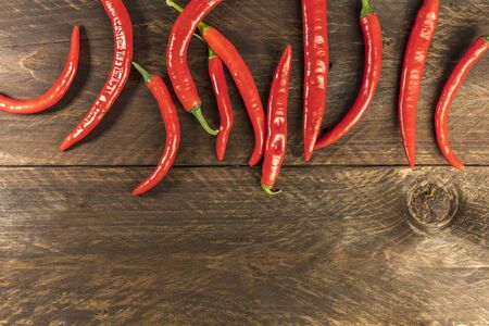 Red hot chili peppers on wooden texture with copyspaceの写真素材
